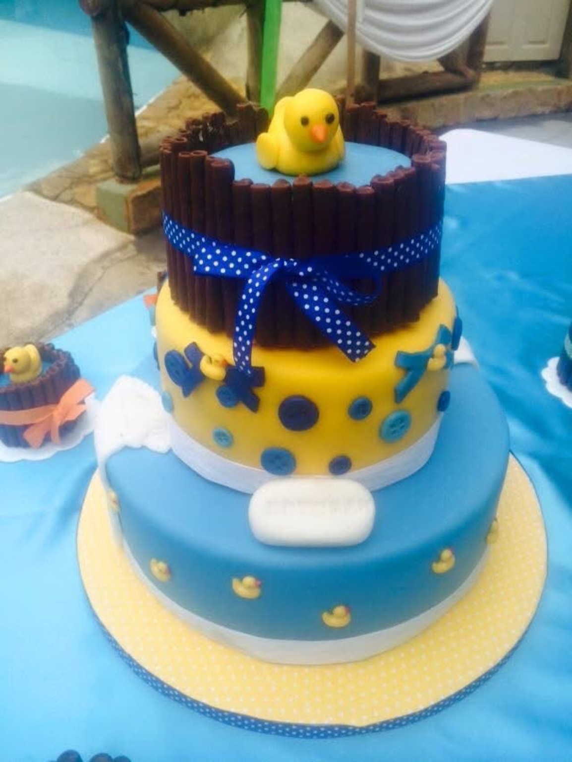 Queque de varios niveles con patitos amarillos y detalles azules
