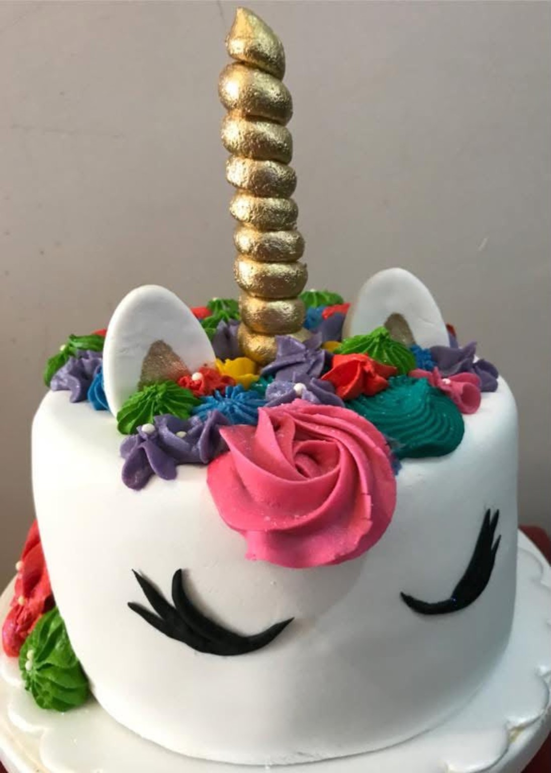 Queque personalizado con temática de unicornio y decoración floral de colores